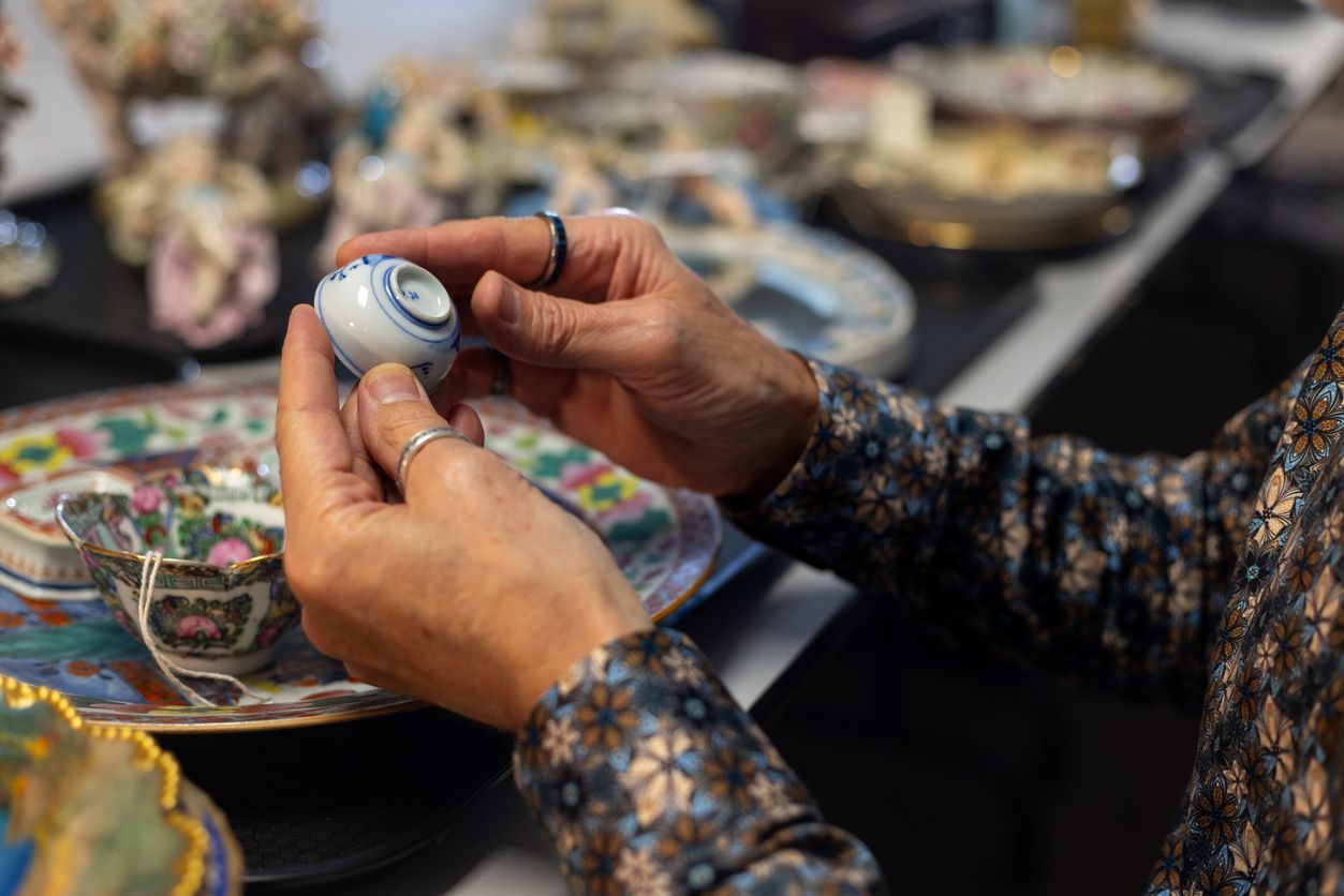 A person is holding a small white object in their hands.