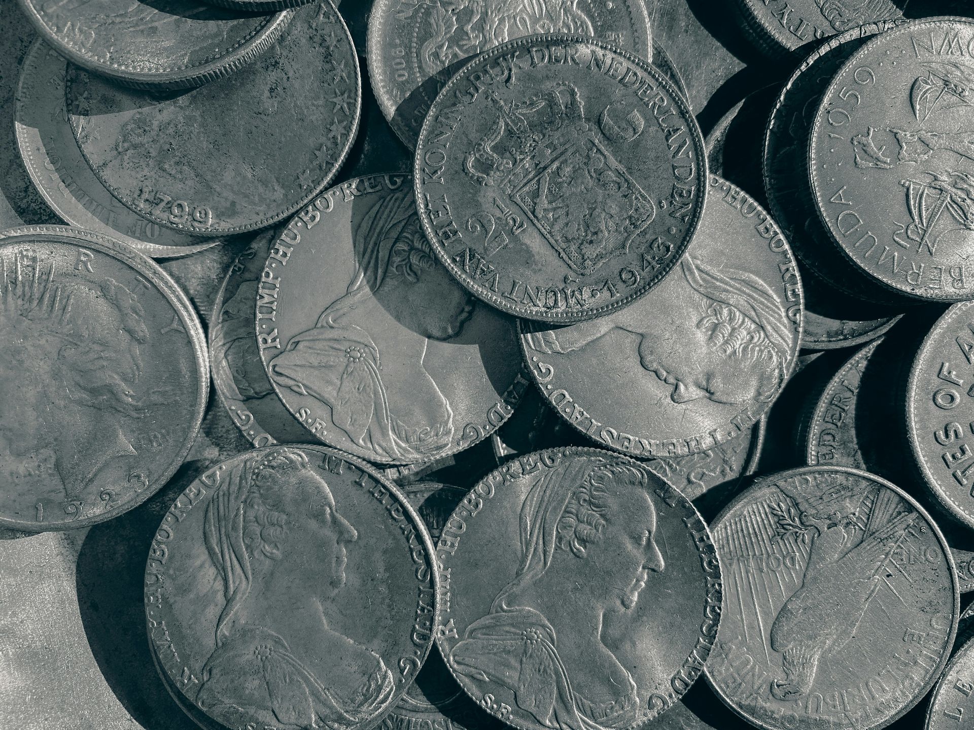 A black and white photo of a pile of silver coins