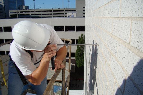 Masonry façade inspection performed from a lift as part of early building envelope maintenance planning.