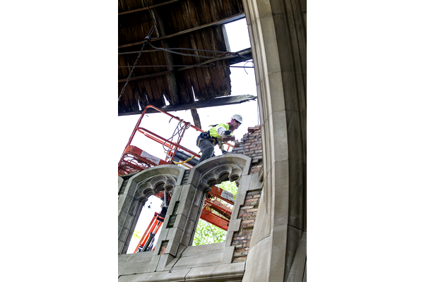 A man in a hard hat is working on a building