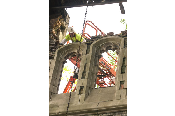 A man is working on a building with a crane.