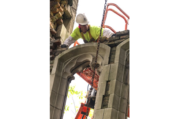 A man is working on a building with a crane.