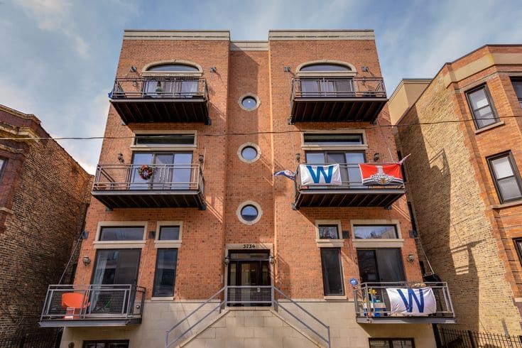 Chicago multi-family brick apartment building showing masonry façade, window systems, and balcony elements typical of local construction.