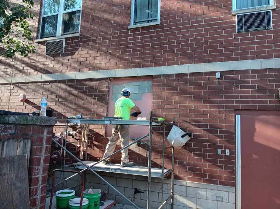 RestoreWorks mason replacing brick during exterior restoration at Churchview Supportive Living in Chicago.