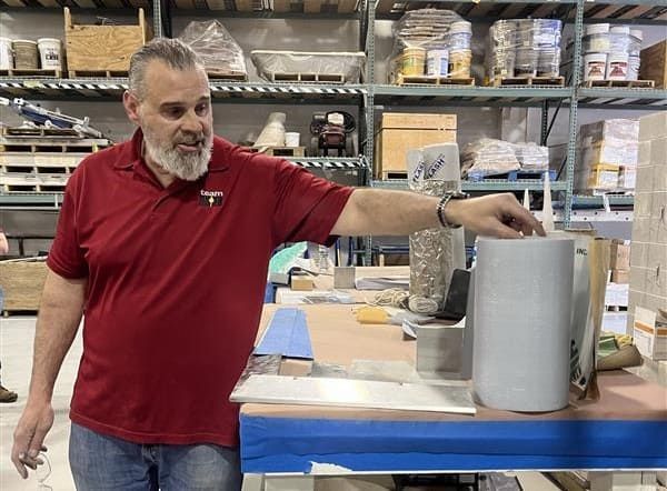 IMI instructor presenting flashing materials—including flexible membrane, drip edge, and sealants—at the lintel and moisture control station during the hands-on masonry restoration workshop co-hosted by RestoreWorks.