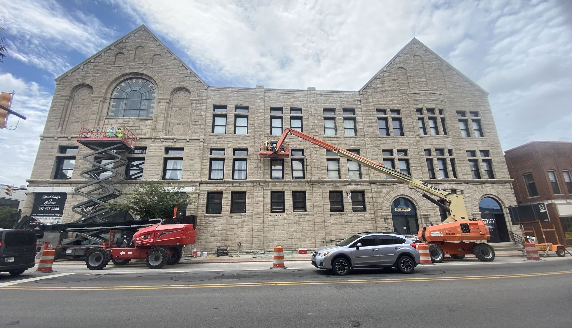 RestoreWorks crews performing exterior masonry restoration on the historic Bradley Hall Events building in Greenfield, Indiana, including lime mortar repointing to preserve the stone façade's breathability and original character.
