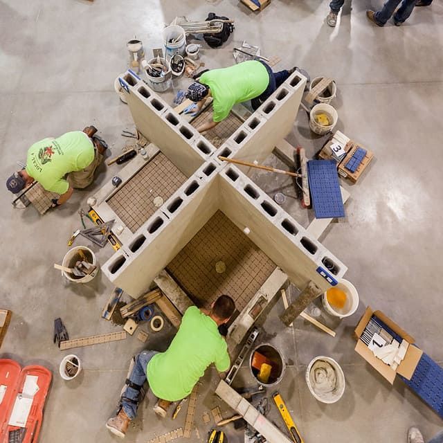 International Masonry Institute training session for members of the International Union of Bricklayers and Allied Craftworkers, showcasing hands-on tile and masonry instruction in a controlled workshop environment.
