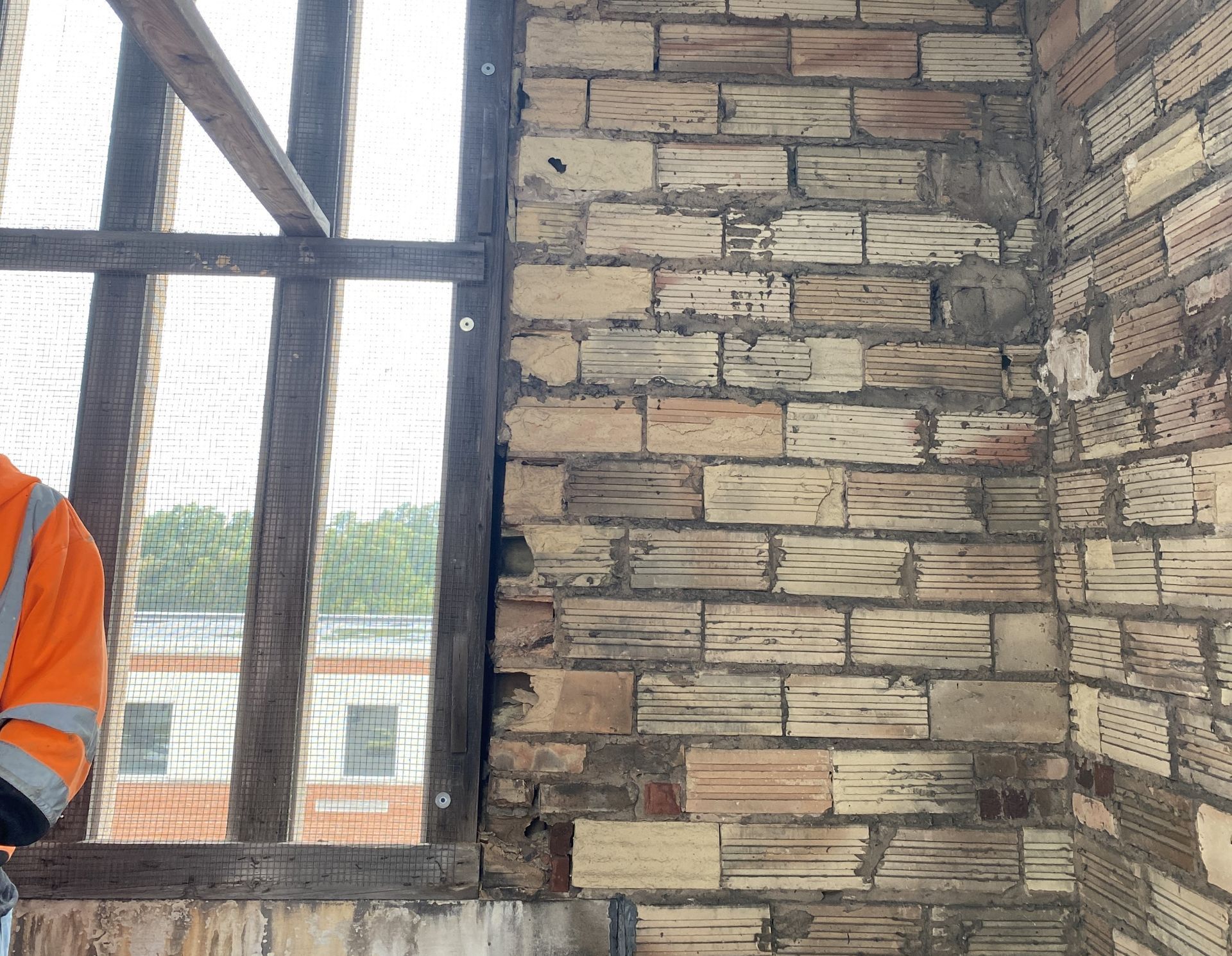 Interior masonry wall showing freeze-thaw damage and deteriorated mortar joints, early signs of moisture infiltration that require professional masonry inspection and repair.