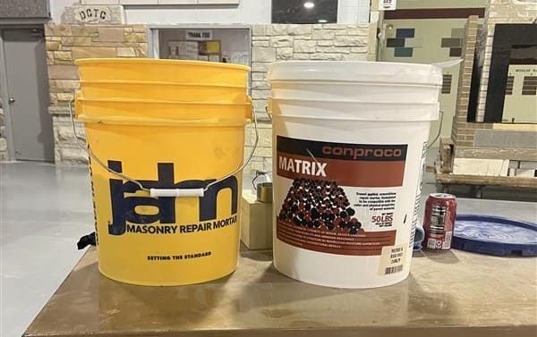 Buckets of Jahn masonry repair mortar and Conproco Matrix repair mortar used during the masonry workshop for historic stone, terra cotta, and limestone patching applications.