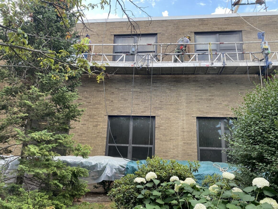 RestoreWorks performing window flashing installation to prevent moisture infiltration and extend the lifespan of this masonry facade.