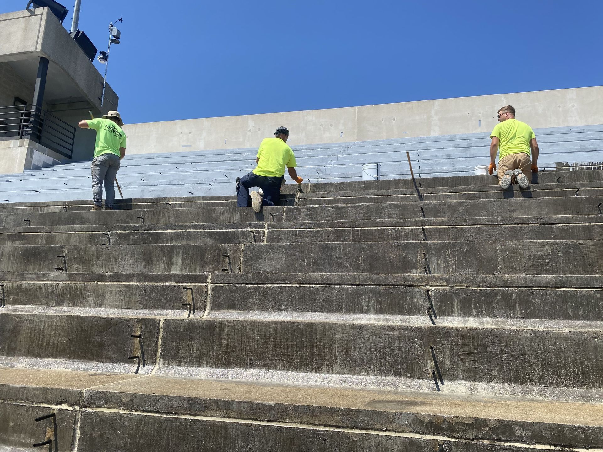 RestoreWorks team installing protective coating on stadium bleachers at Merrillville High School in Northwest Indiana. Part of preventative maintenance to extend the life of concrete structures in educational facilities.