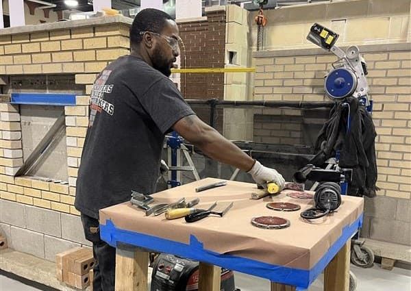 Instructor preparing tuckpointing tools and diamond blades for a mortar joint removal demonstration