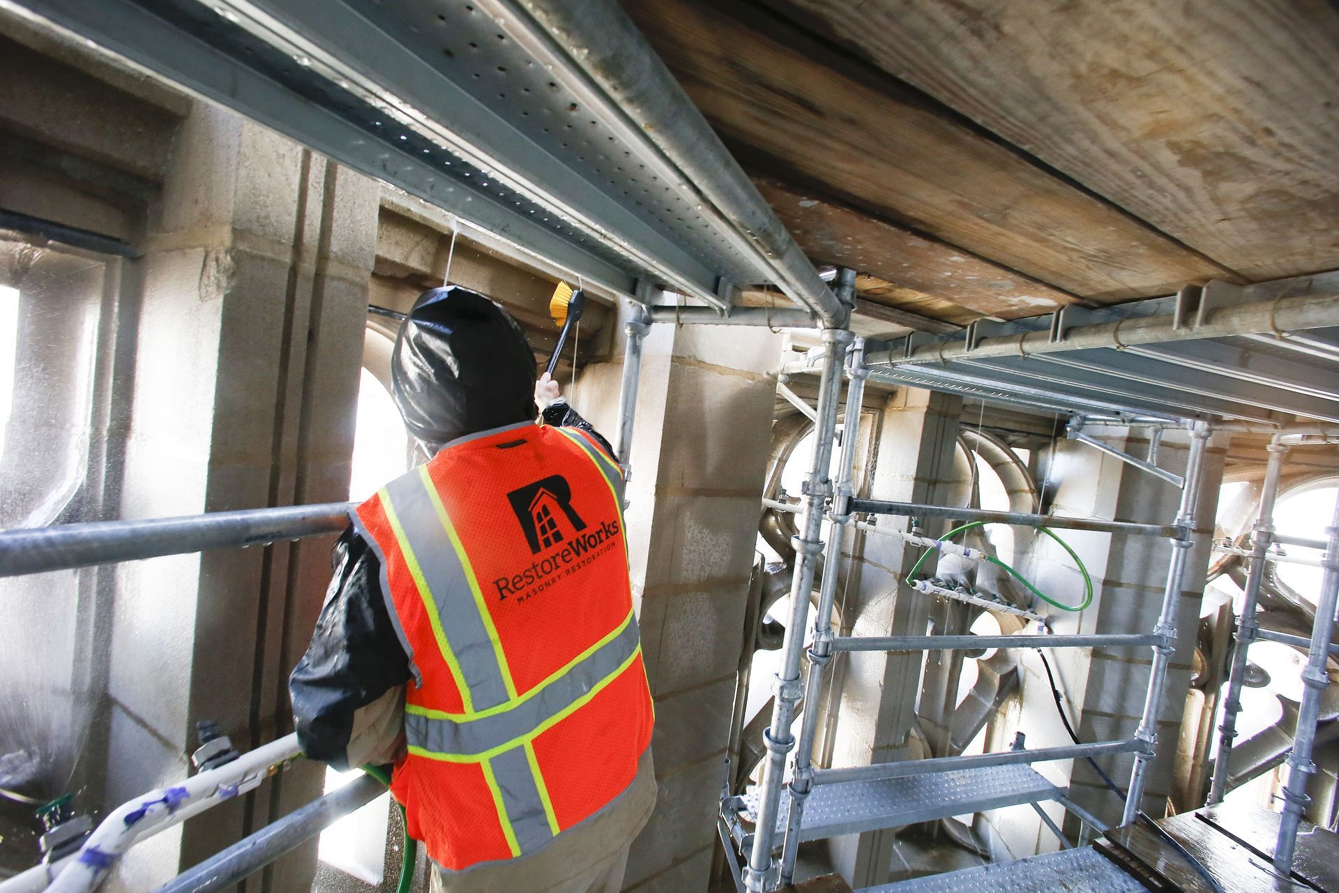 RestoreWorks performing restorative masonry cleaning at Tribune Tower Residences in Chicago, safely removing buildup from historic limestone facade using specialized cleaning methods.