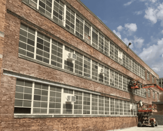 RestoreWorks crew performing large-scale window lintel replacement on a multi-story brick commercial building to improve structural support and reduce thermal bridging.