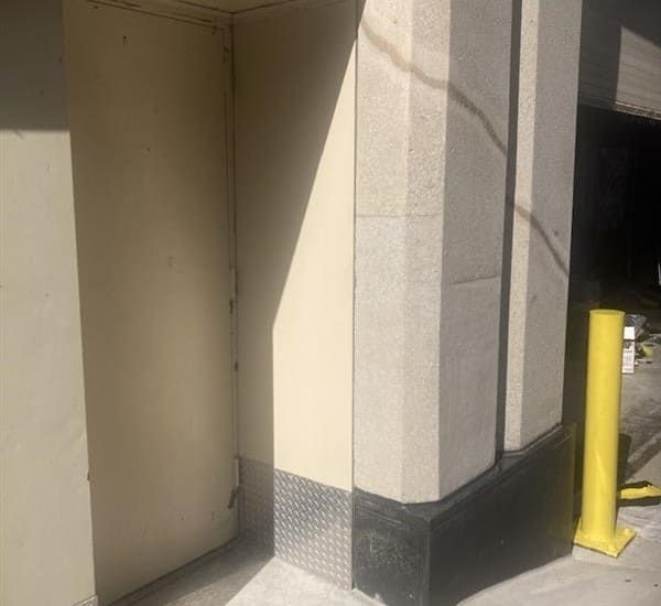 Sheet metal installation around access doorway and column base at the Sheraton Grand Chicago Riverwalk showing integrated finish with restored concrete and bollard.