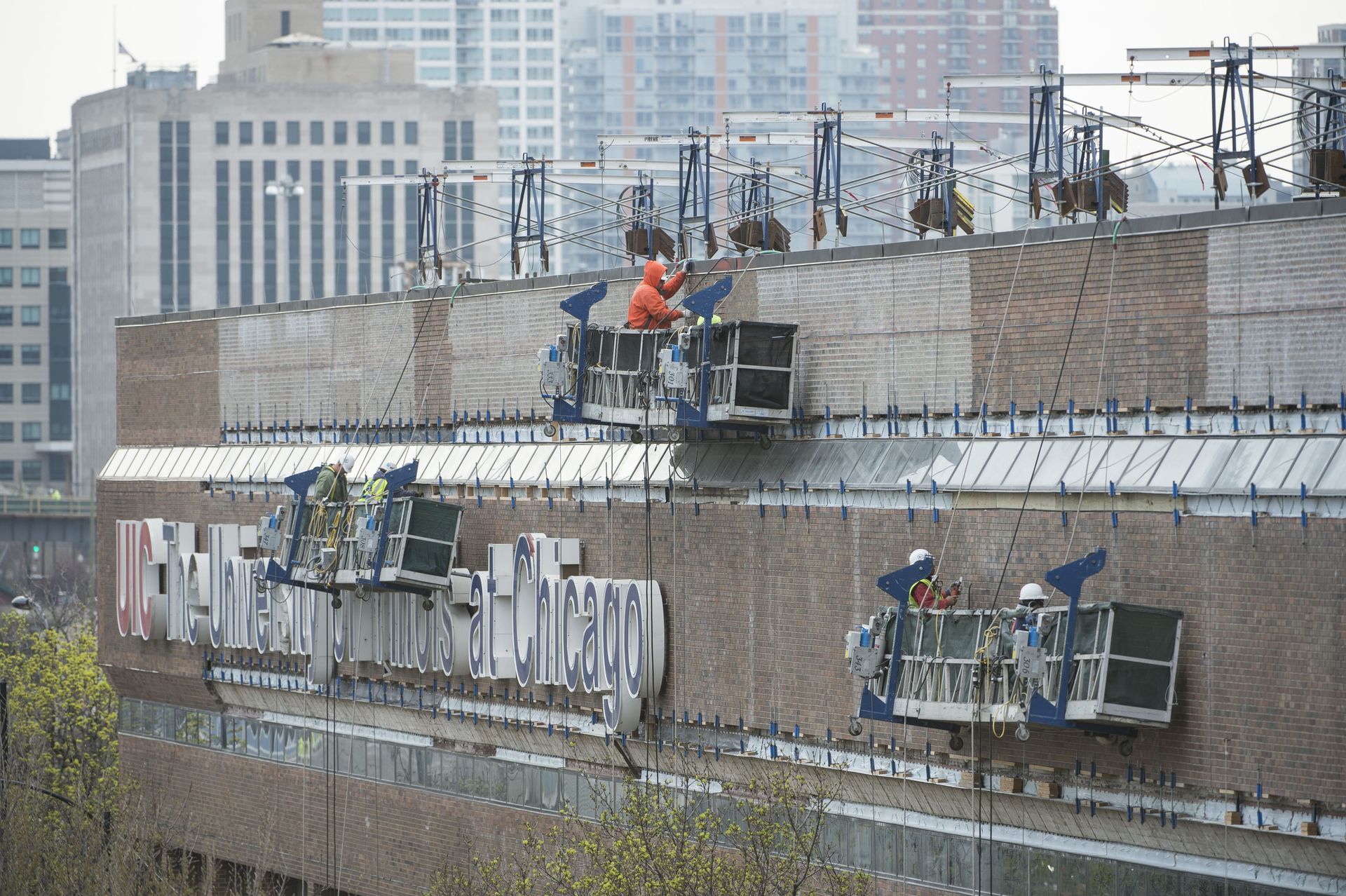 RestoreWorks crew performing tuckpointing and facade restoration at the University of Illinois Chicago, addressing deteriorated mortar joints on a high-rise educational building in downtown Chicago.