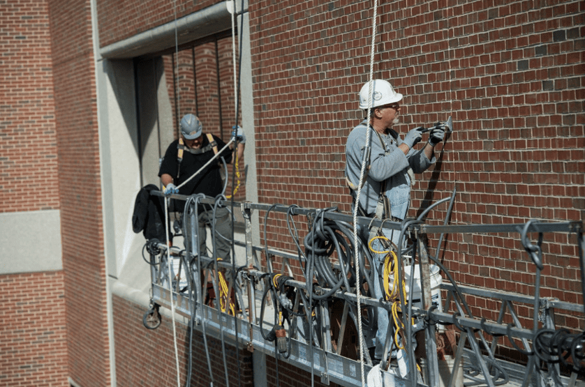 RestoreWorks crew on a suspended scaffold addressing sealant damage on a hospital facade in Chicago.
