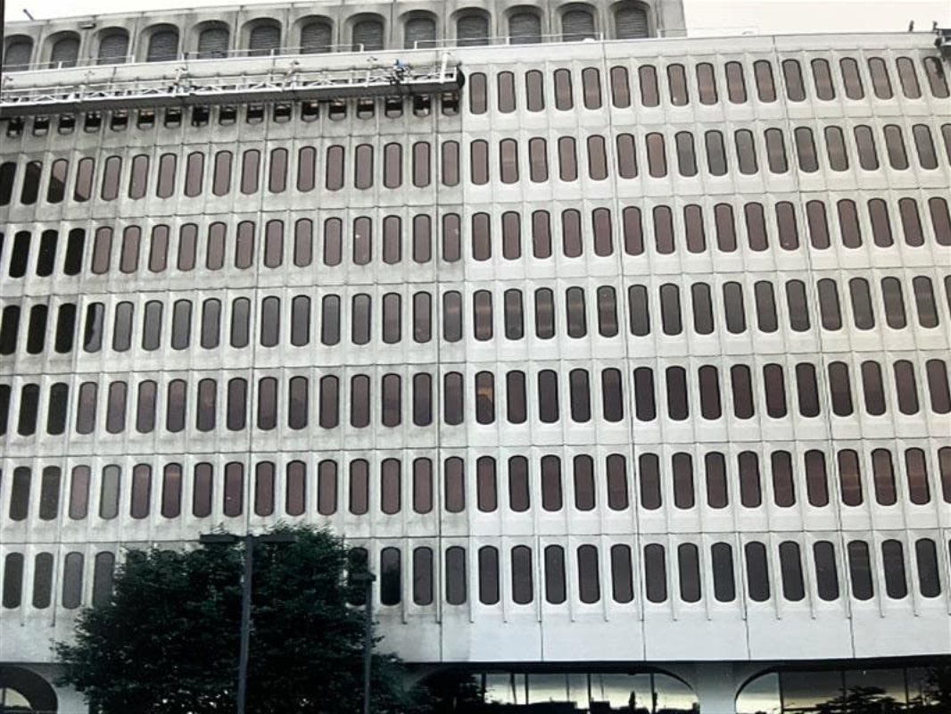Before and after abrasive cleaning on the former McDonald’s Headquarters façade, showing removal of heavy buildup and the importance of verifying media cleanup after surfaces fully dry.