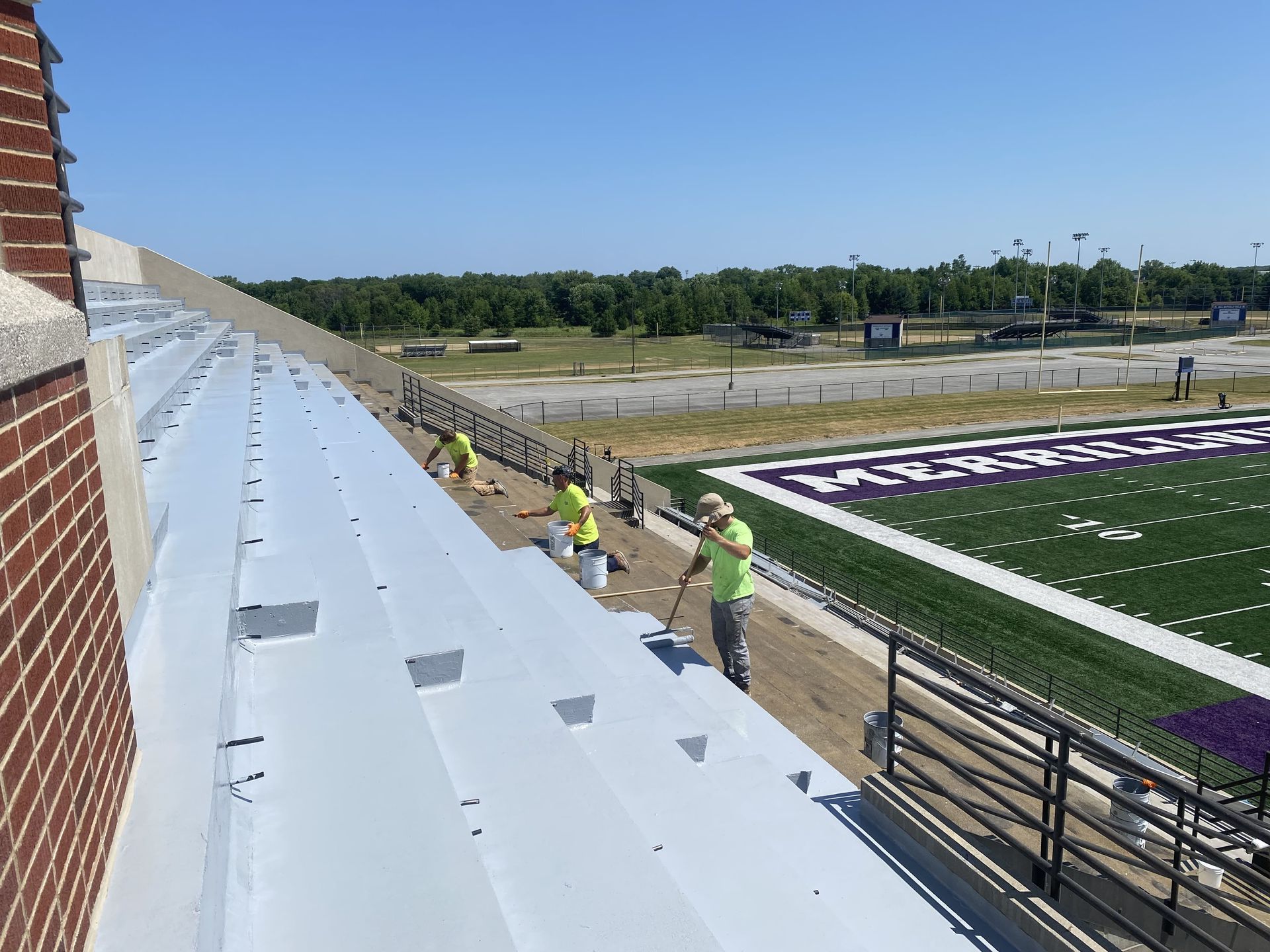 RestoreWorks crew applying protective coatings to concrete bleachers at Merrillville High School’s football stadium in Northwest Indiana to enhance durability and performance.