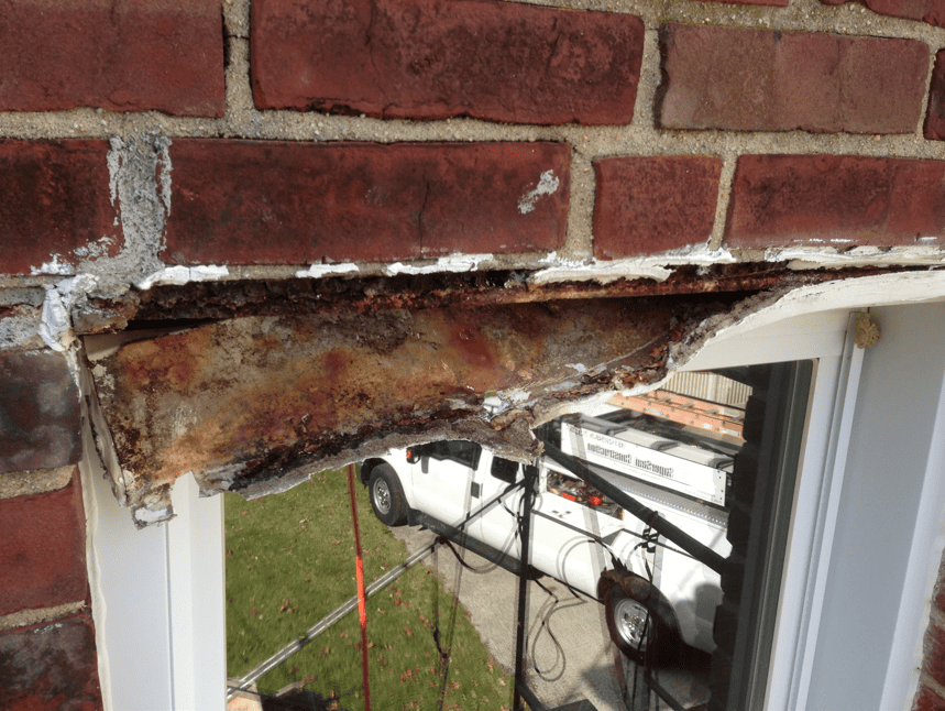 Close-up of rusted steel lintel causing brick cracking and movement — example of root-cause masonry failure common in Chicago buildings.