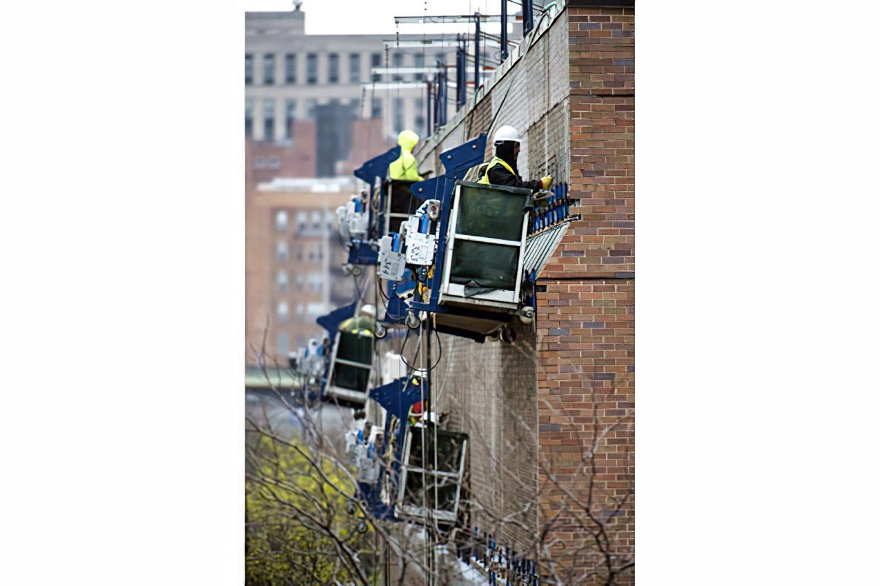 A group of construction workers are working on a brick building at University of Illinois-Chicago