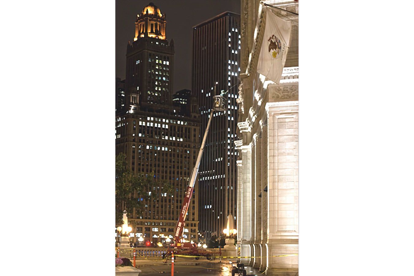 A crane is being used to clean a building at night
