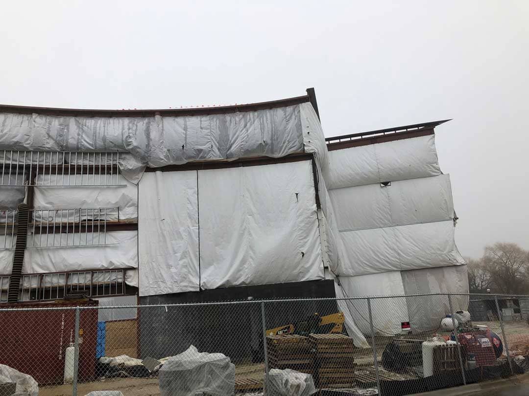 Cold weather enclosure used during winter concrete repair to maintain curing conditions.