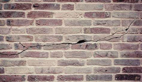 Horizontal crack across a brick facade, indicating potential structural movement or settlement issues requiring masonry inspection and repair.