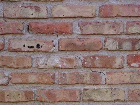Close-up of a brick wall with visible mortar cracks, indicating potential structural movement and the need for masonry repair or tuckpointing services.
