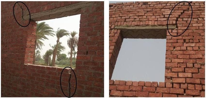 Cracked and displaced brick masonry around window openings showing movement from freeze–thaw pressure and building settlement.