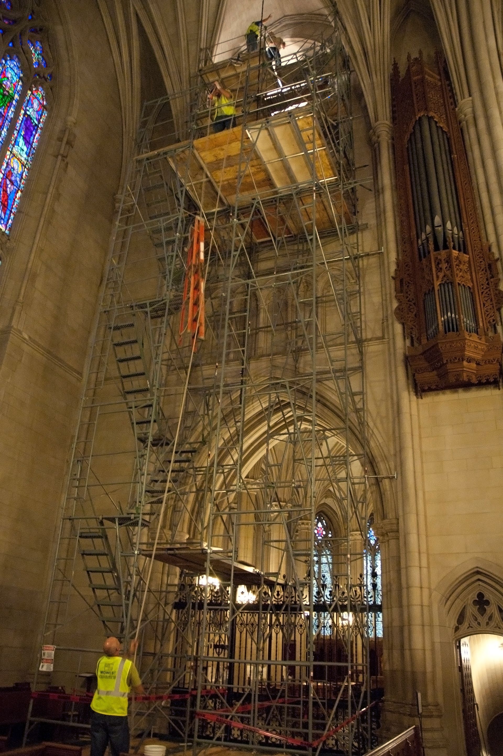 A man is standing on a scaffolding in  Duke University's Chapel