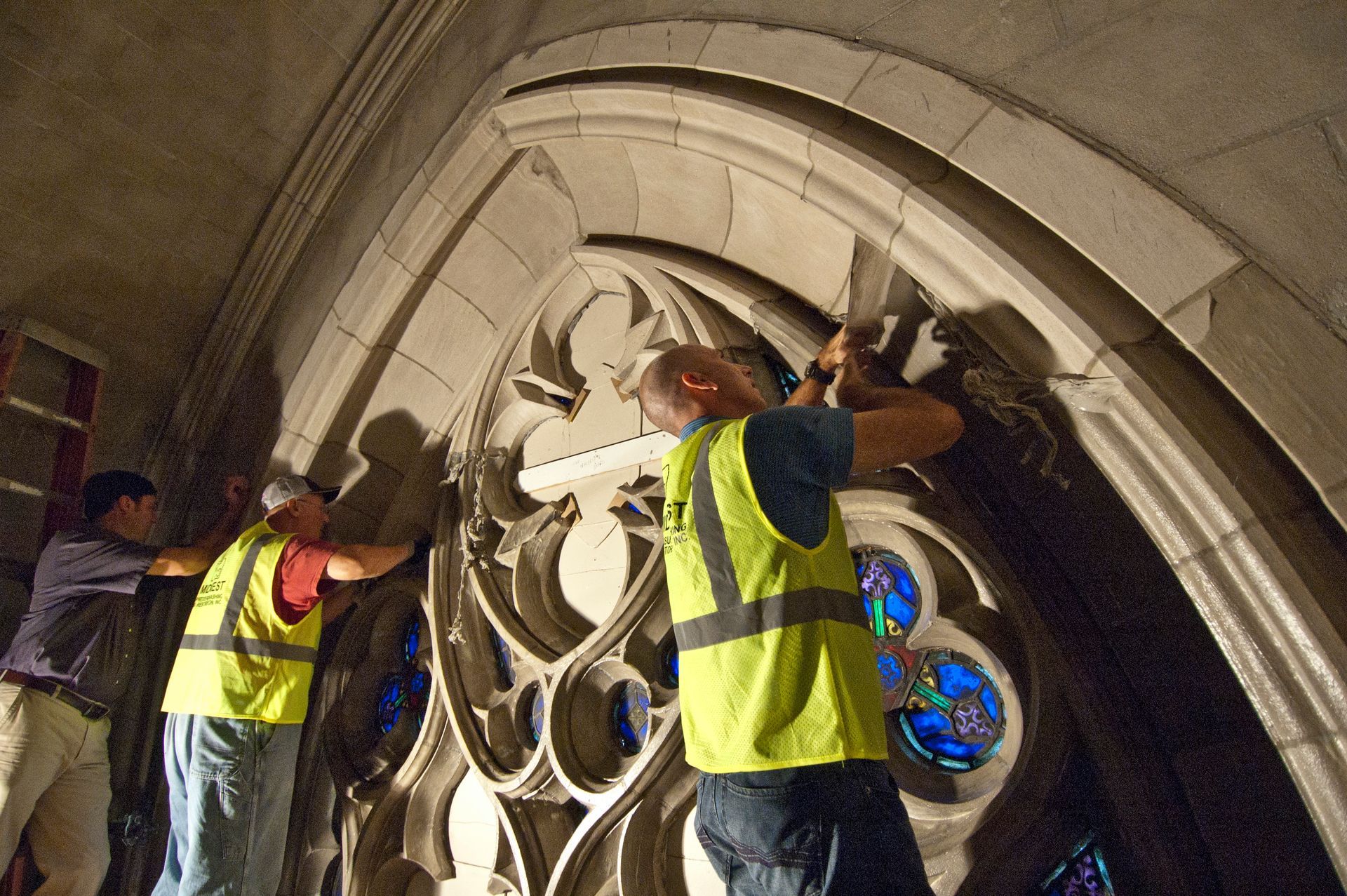 A group of men in yellow vests are working on Duke University's Chapel