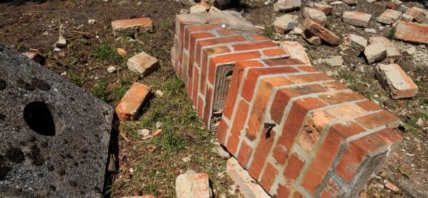 Broken brick chimney that is in need of emergency masonry repairs.