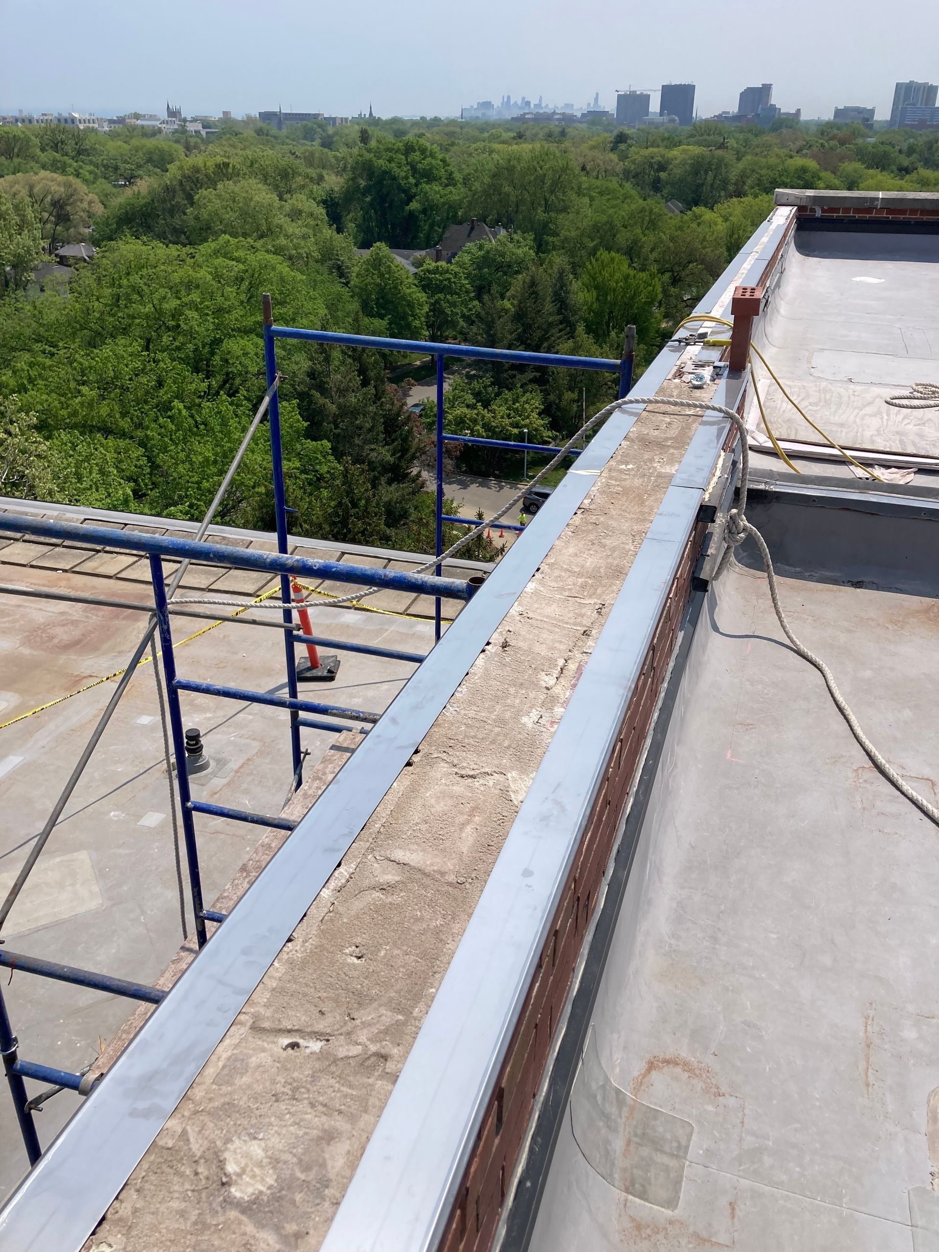 A roof with a scaffolding on it and trees in the background