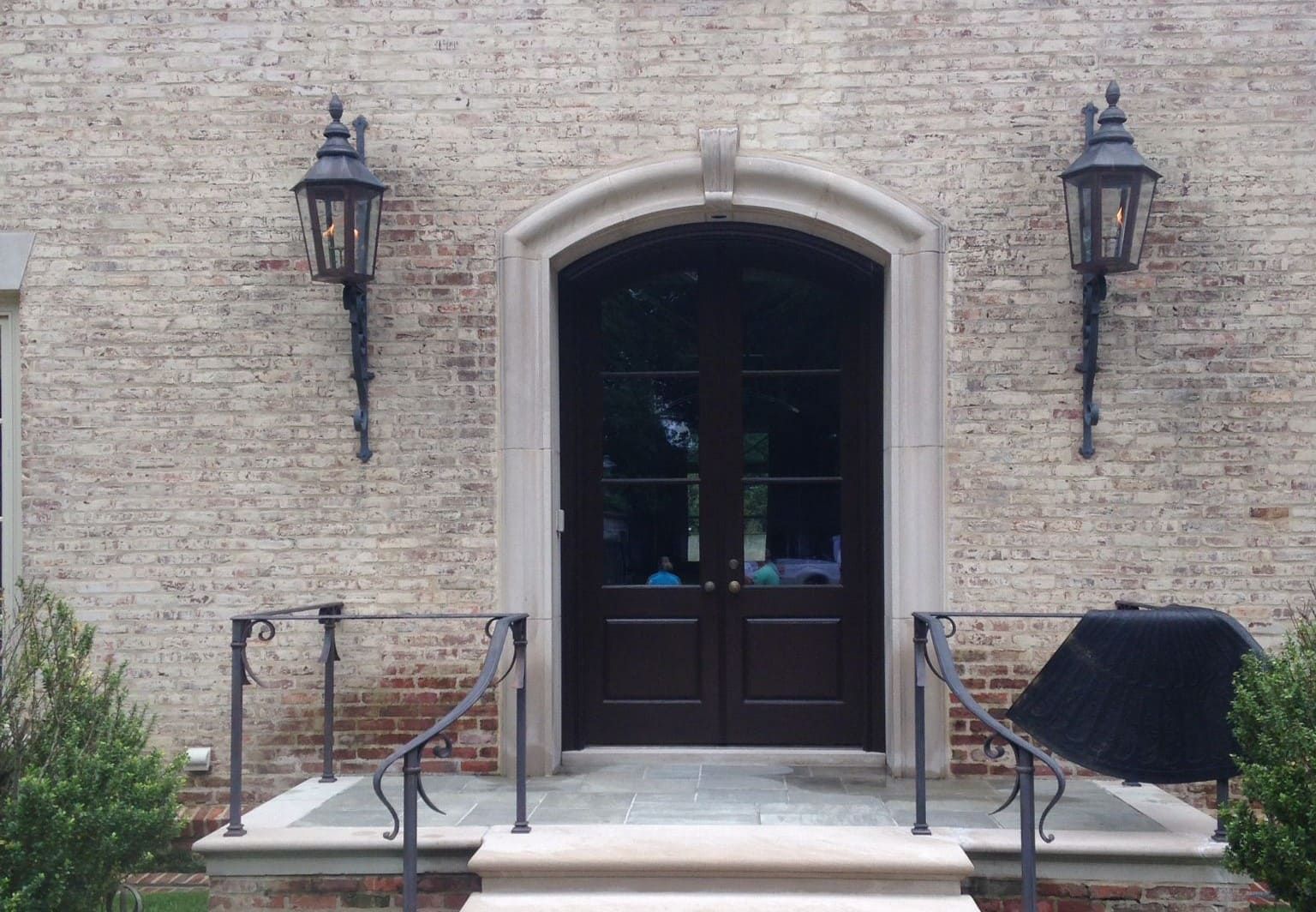 Limestone entryway with uneven weathering and mixed surface coloration, illustrating how prior treatments and sun exposure influence cleaning outcomes when no test panel is performed.