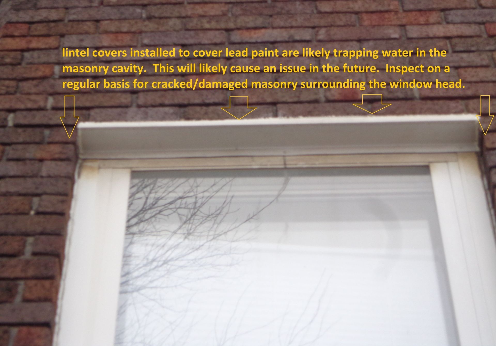 Window lintel covers trapping moisture behind masonry, flagged during RestoreWorks inspection for potential water damage and future masonry cracking.