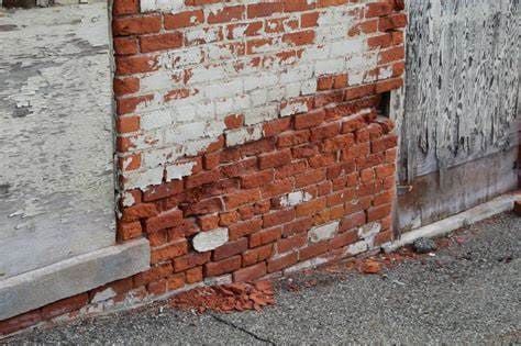 Brick wall with severe spalling caused by moisture infiltration and freeze-thaw damage. Early masonry repairs can stop further deterioration and protect structural integrity