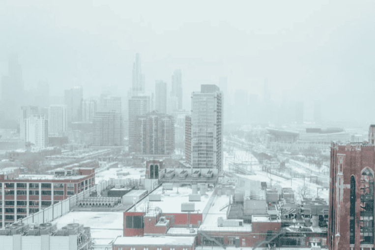 Winter skyline of Chicago with snow-covered rooftops, illustrating the freeze–thaw conditions and moisture exposure that accelerate steel lintel corrosion and masonry damage.