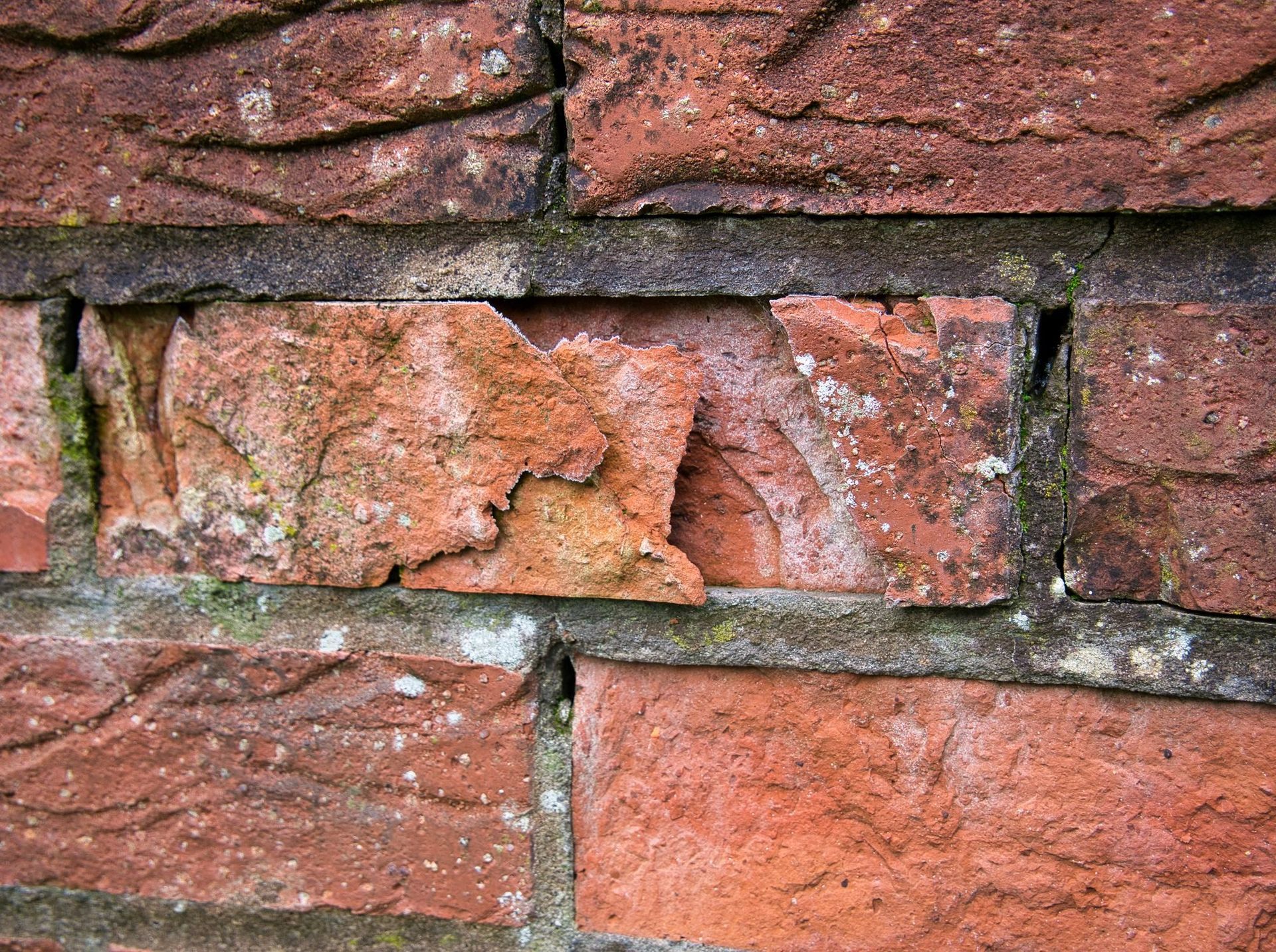 Spalling brick on a painted masonry facade