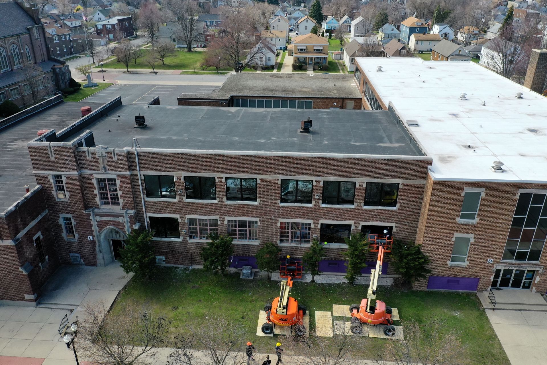 Aerial view of St. Casimir Catholic School in Hammond, Indiana, during masonry restoration by RestoreWorks, including tuckpointing, brick replacement, window upgrades, and sealant repairs to protect the building envelope.