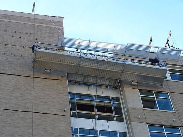 Suspended swing stage in use on the exterior of a Chicagoland hospital for facade access and repair work.