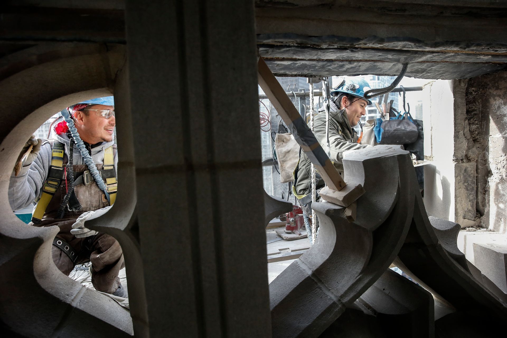 Two construction workers are working on a building.
