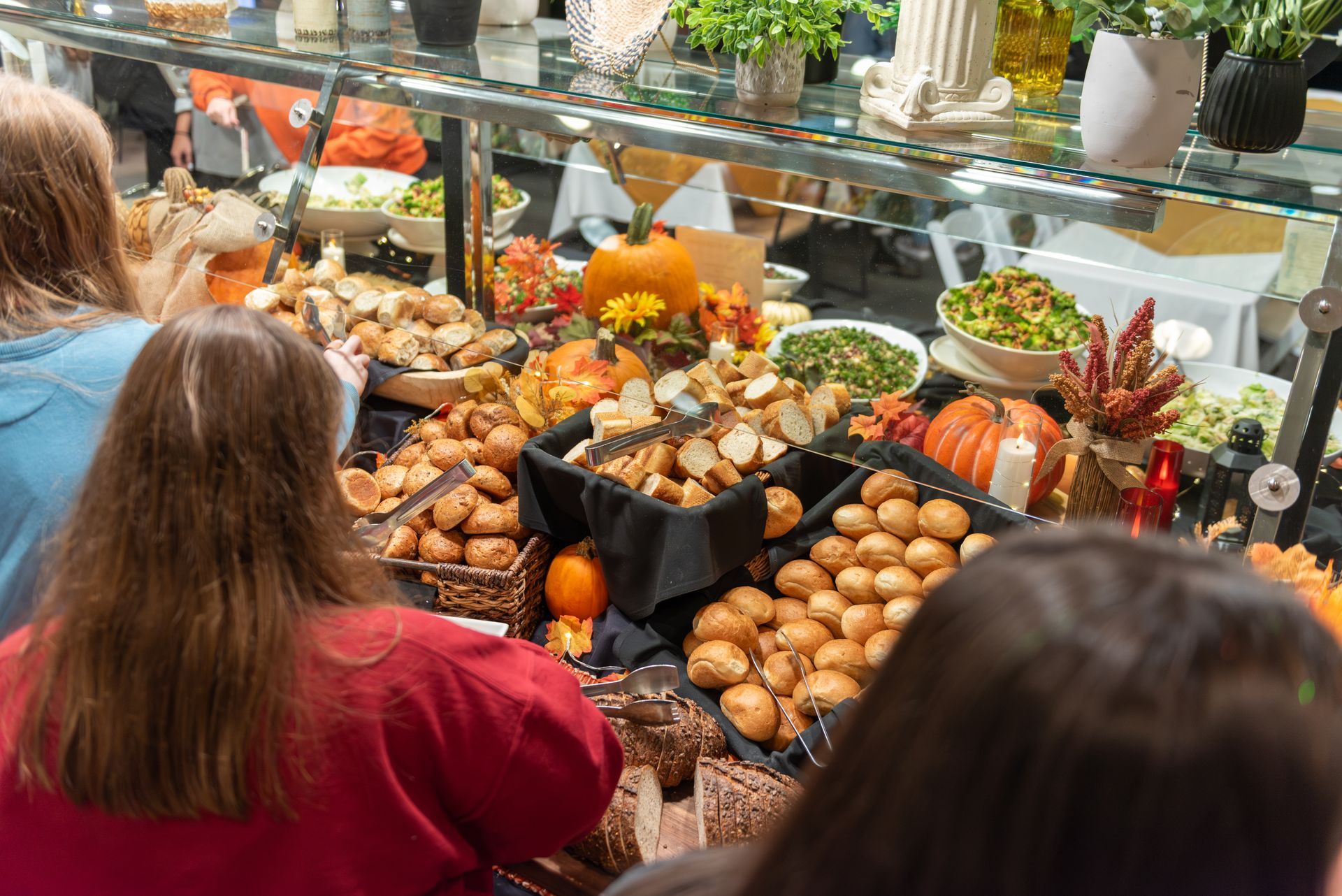 Chef in black uniform stands behind food display at a dining counter; beverages and W & J sign in the background.