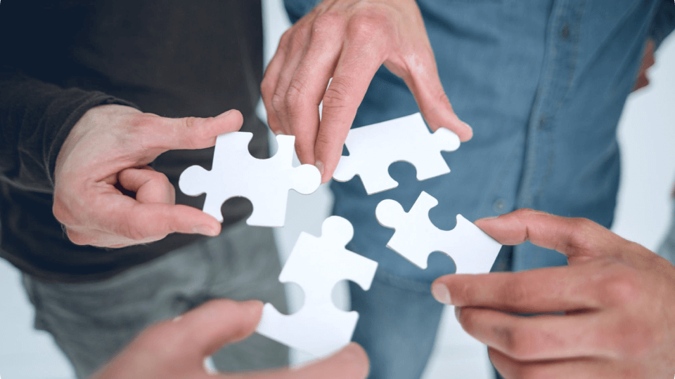 A group of people are putting puzzle pieces together.
