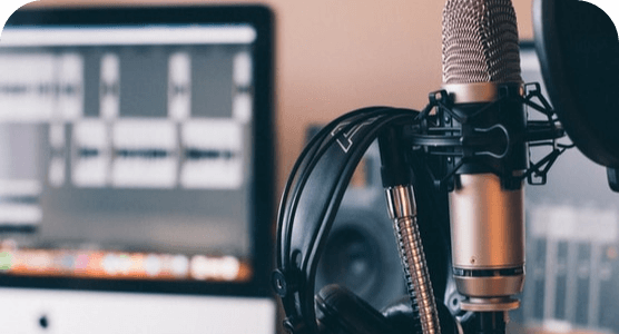 A microphone and headphones are sitting in front of a computer.