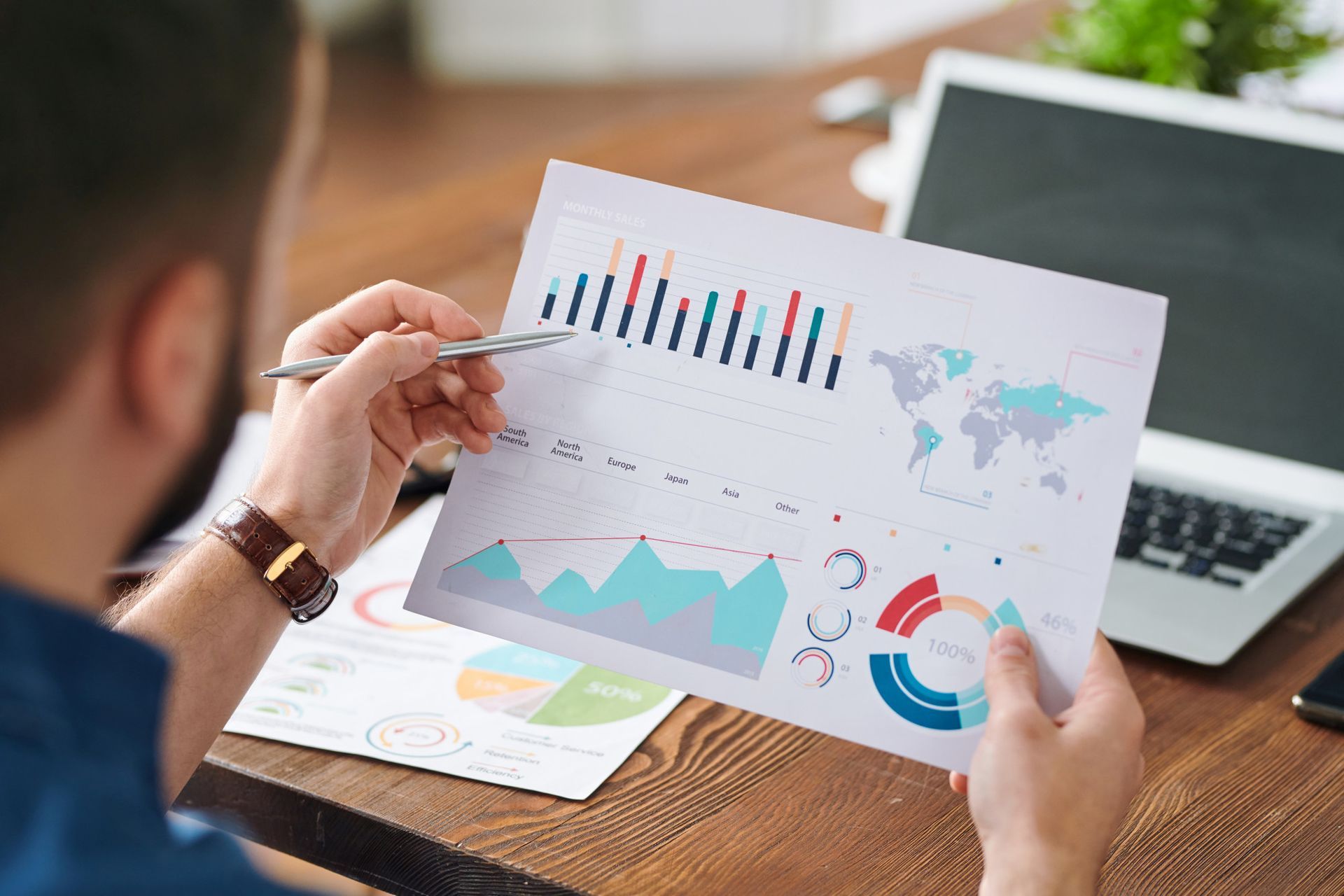 A man is holding a piece of paper with a graph on it.