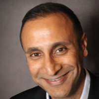 A man in a suit is smiling for the camera