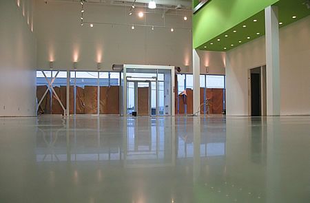 A large empty room with a green ceiling and white walls.
