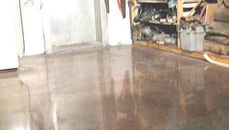 A person is standing on a shiny concrete floor in a garage.