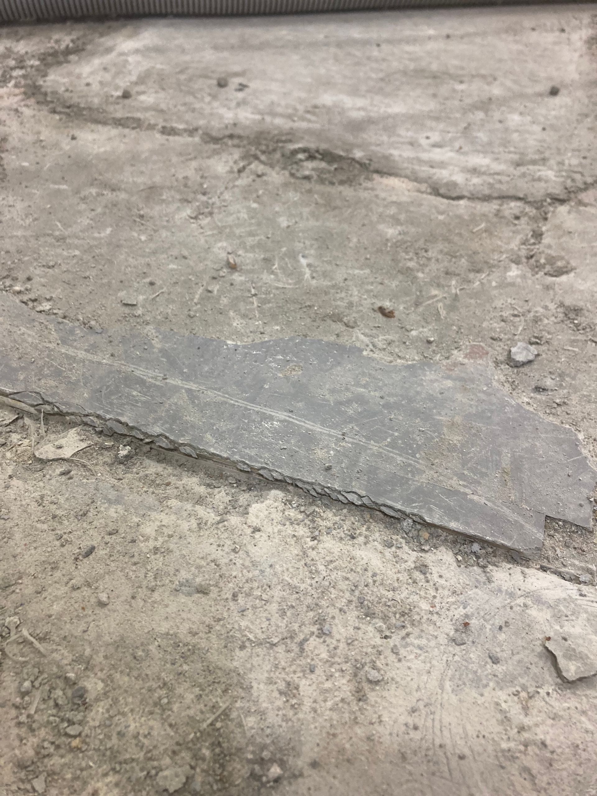 A close up of a concrete floor with a few pieces of concrete on it.
